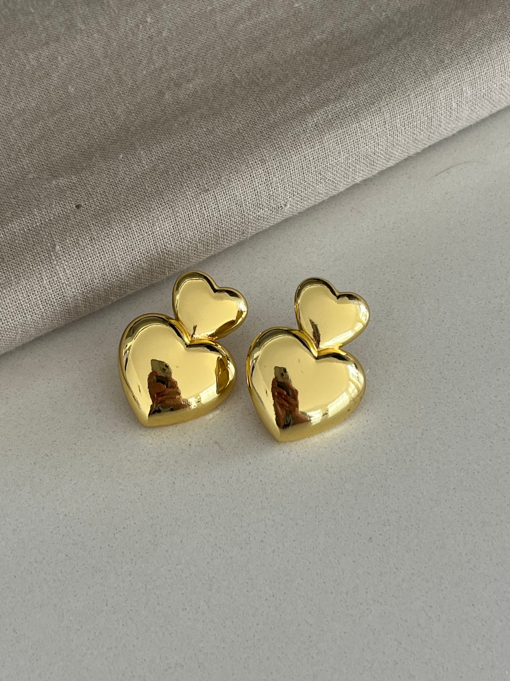 Aretes dorados con dos corazones unidos tipo topo
