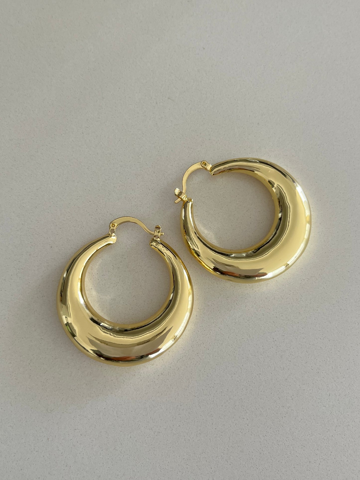 Argollas doradas lisas con diseño dual: clip y topo en perfecta armonía