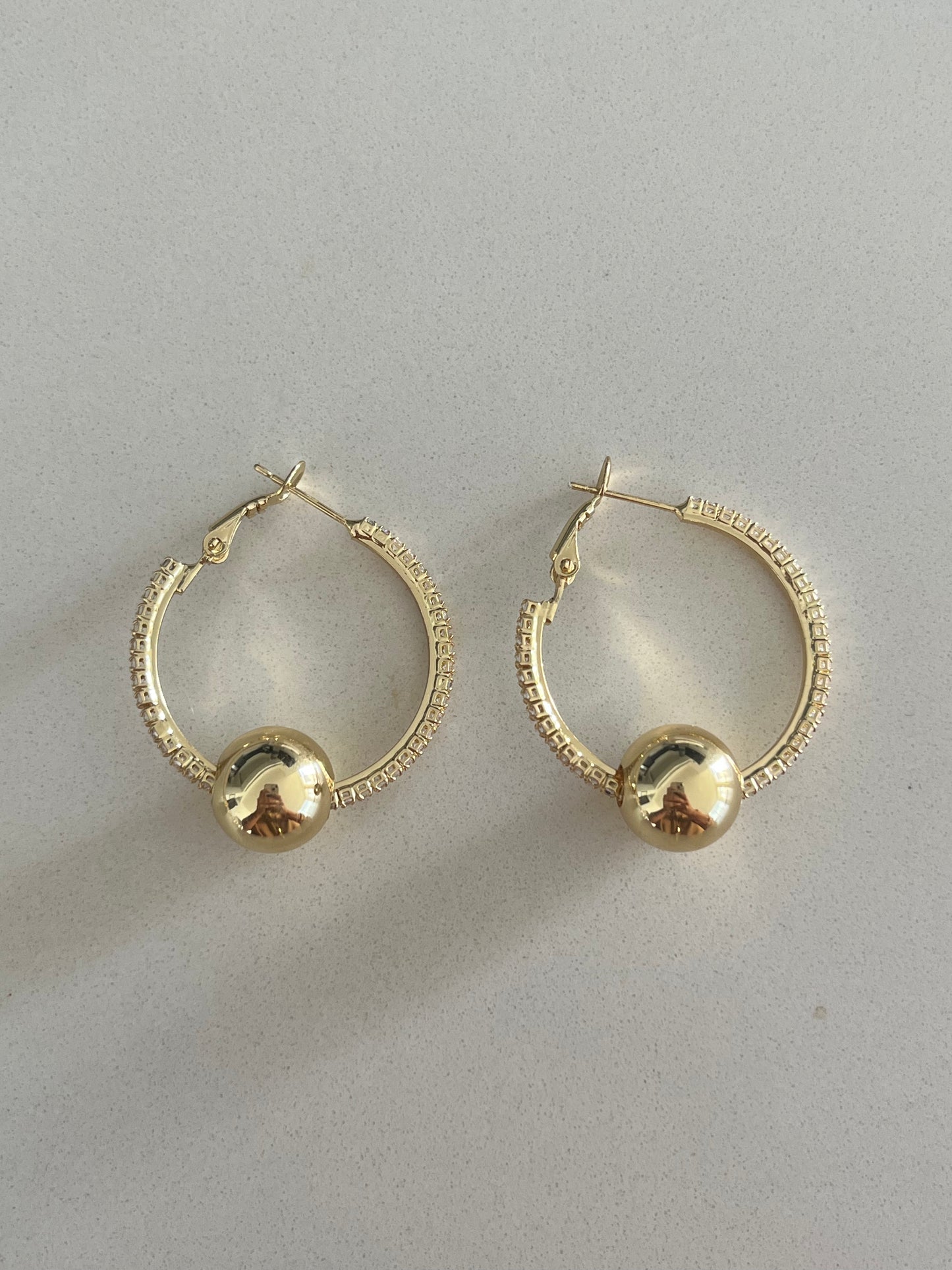 Aretes de aro medianos con esfera dorada y borde brillante